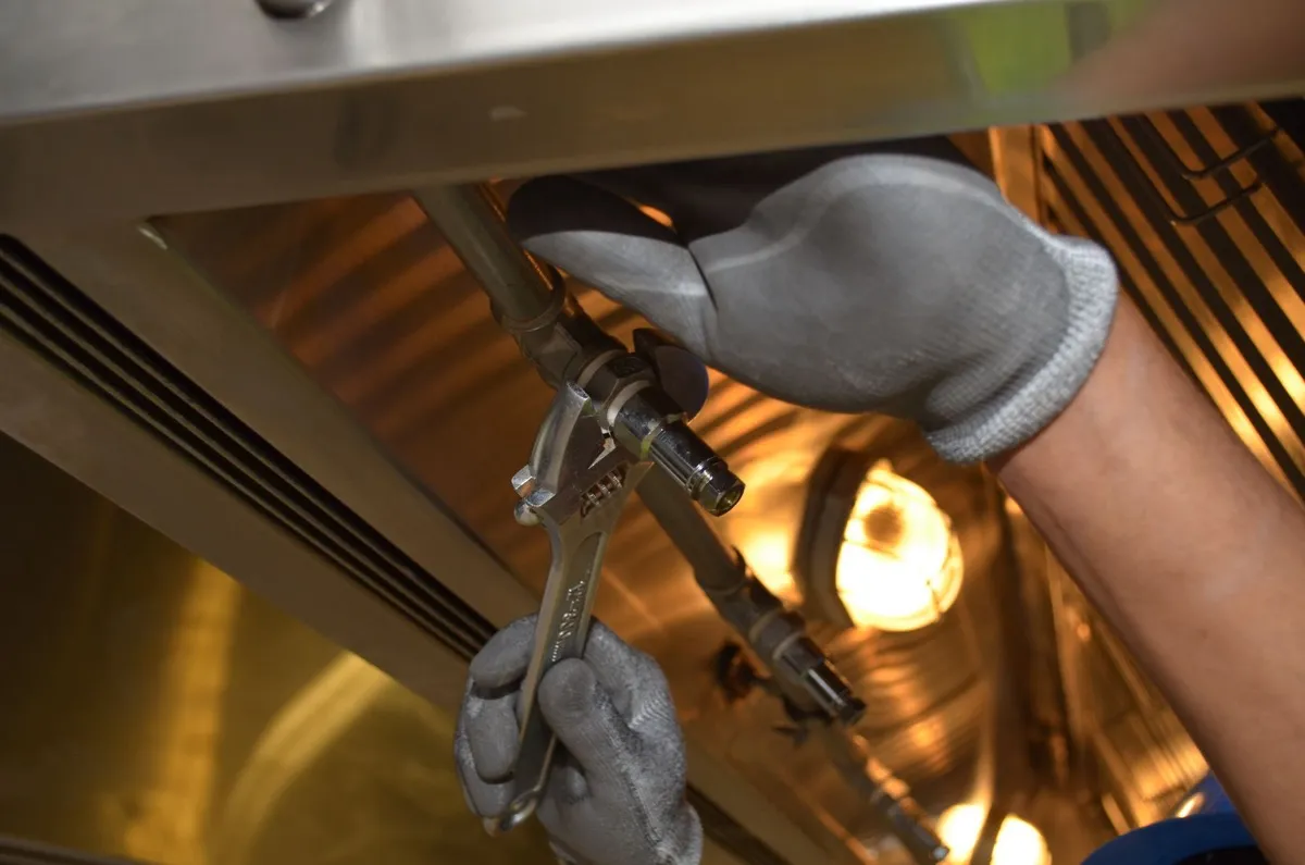 Plumber working on a pipe with a spanner