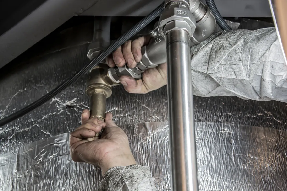 Plumber connecting copper pipework to a hot water system